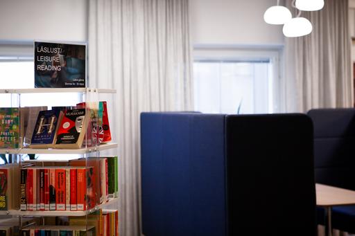 Avskilda studieplatser och bokhylla i biblioteksmiljö.